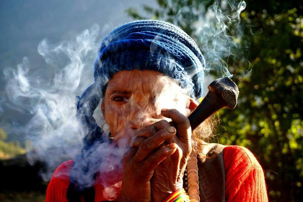 Népal Femme fumant la pipe traditionnelle