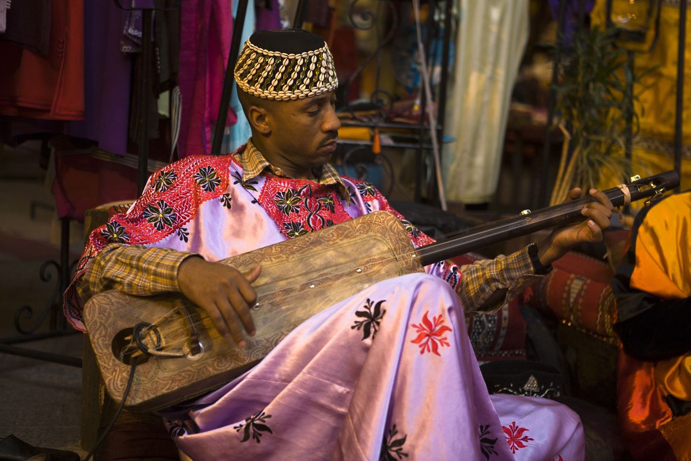 Maroc Marrakech Musicien gnaoua jouant du guembri