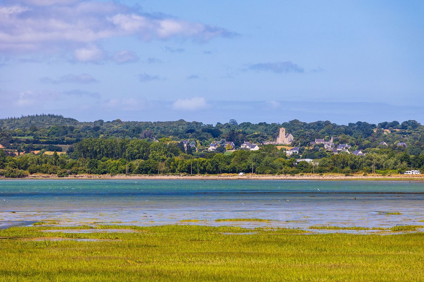 Maisons au bord de la mer dans le village de Quettehou, de l’autre côté de l’anse du Cul-de-Loup depuis Saint-Vaast-la-Hougue